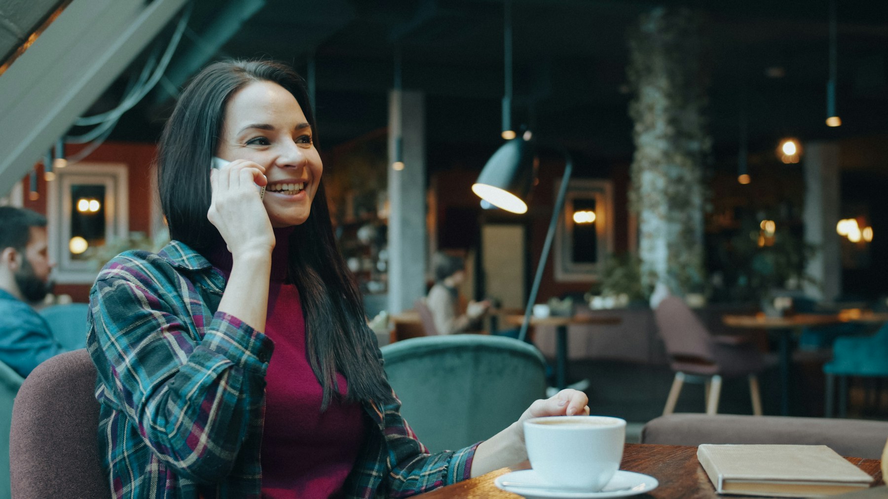 Smiling customer on the phone in a café, the moment to ask for customer feedback