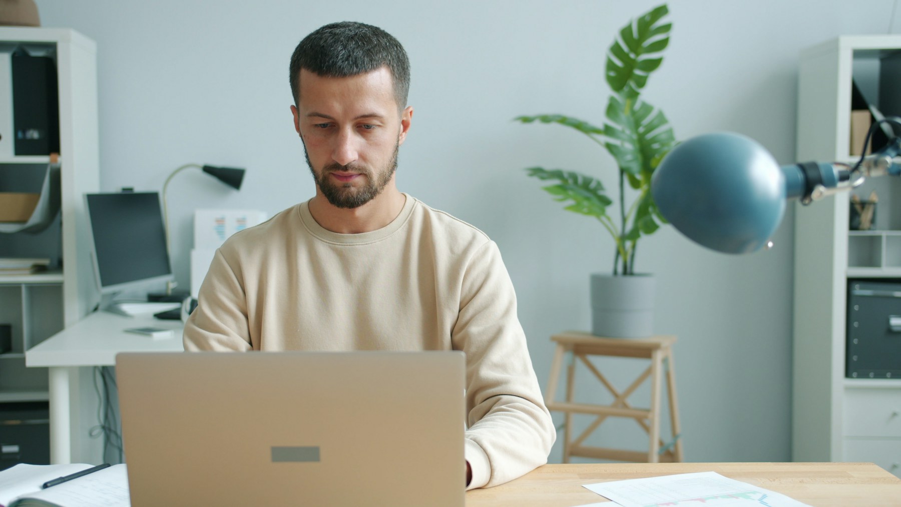 Man building a form on his laptop at a tidy home-office desk