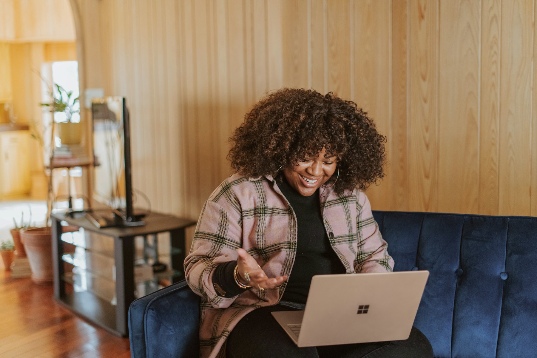 Woman on a couch answering an online survey on her laptop
